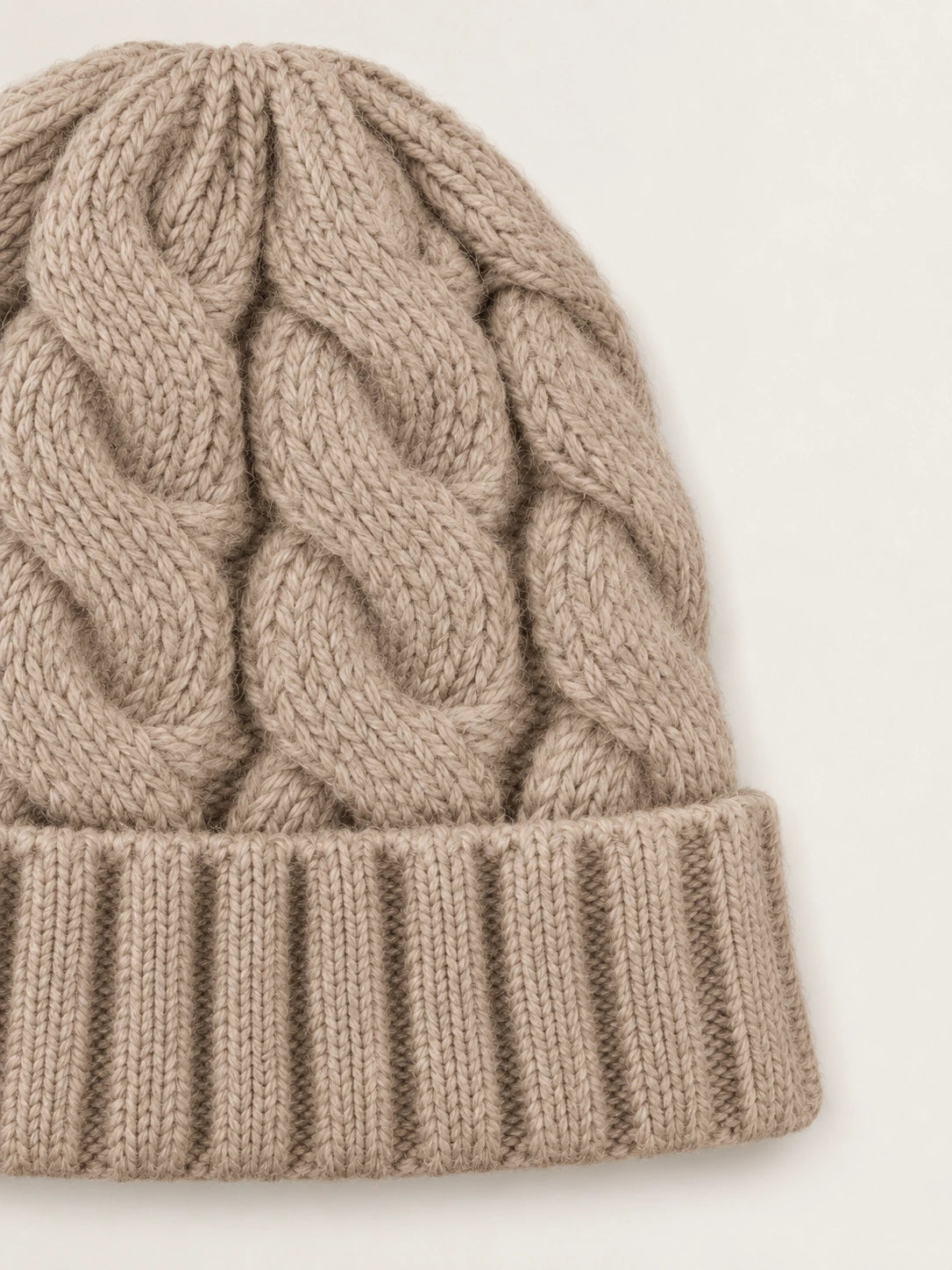 Closeup of the beige cable knit and folded cuff